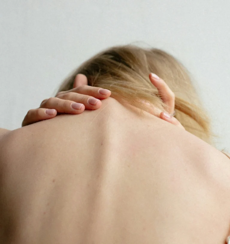 Eine Frau dehnt sanft ihren Hals, um Nackenverspannungen zu lösen.